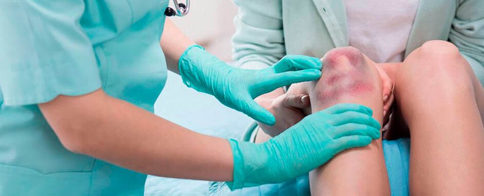 the doctor examines a knee injury